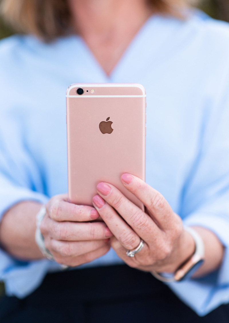A close up of Beth holding a phone